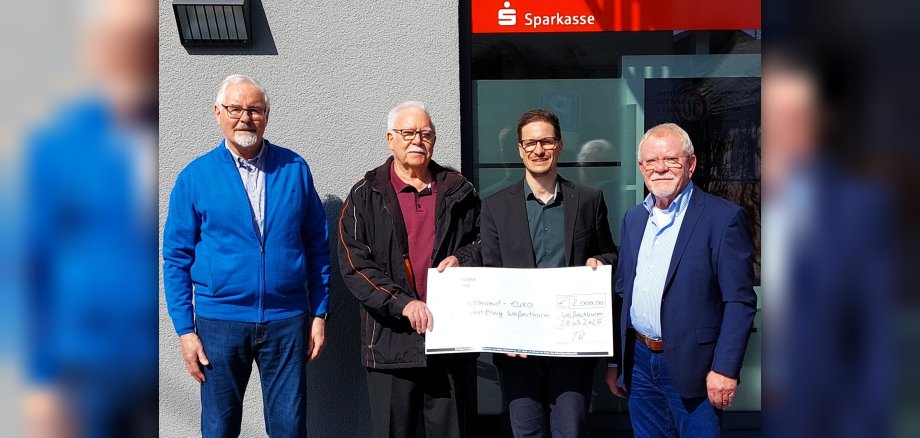 Der Vorstand der Bürgerstiftung steht mit dem Weißenthurmer Filialleiter Thorsten Escher vor dem Sparkassengebäude mit einem großen Scheck. 